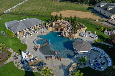 Tchupala U - Medford, NJ - A bird's eye view of a backyard with a large swimming pool and a waterfall