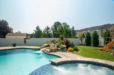 Thika D - Berlin, NJ - A backyard with a swimming pool and a waterfall feature