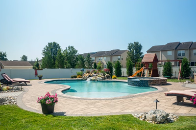 Thika K - Berlin, NJ - A backyard with a swimming pool surrounded by landscaping and a play area