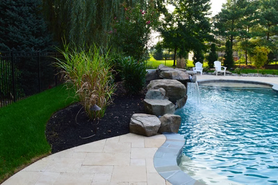 Thoreau D - Moorestown, NJ - A backyard with a swimming pool surrounded by lush green grass and trees