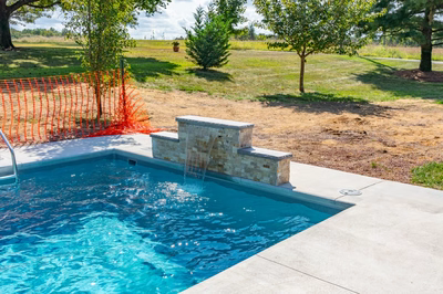 Tississat E - Mullica Hill, NJ - A swimming pool with a waterfall in the middle of a grassy area.