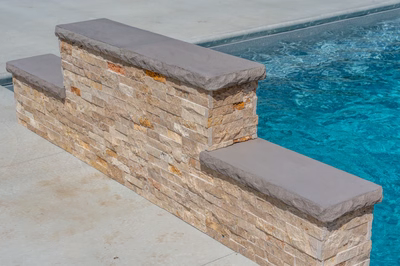 Tississat F - Mullica Hill, NJ - A brick retaining wall next to a swimming pool with clear blue water.