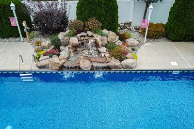 Tugela H - Sayreville, NJ - A backyard with a swimming pool and a waterfall feature