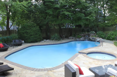 Tully E - Voorhees, NJ - A backyard with a swimming pool surrounded by lush greenery and a wooden fence