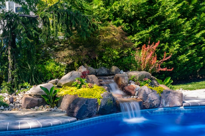 Tumalo E - Freehold, NJ - A small waterfall in the middle of a lush garden next to a swimming pool