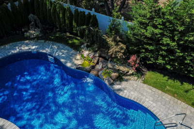 Tumalo G - Freehold, NJ - A bird's eye view of a swimming pool surrounded by lush greenery and rocks