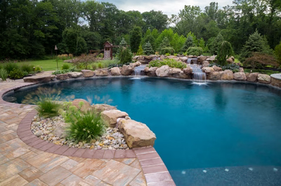 Tunnel D - Ringoes, NJ - A swimming pool surrounded by lush greenery and a waterfall.