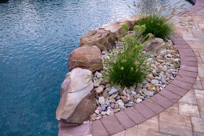 Tunnel F - Ringoes, NJ - A rock garden by a swimming pool with a brick edging around it