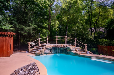 Vernal B - Media, PA - A swimming pool surrounded by lush green trees and a wooden fence.