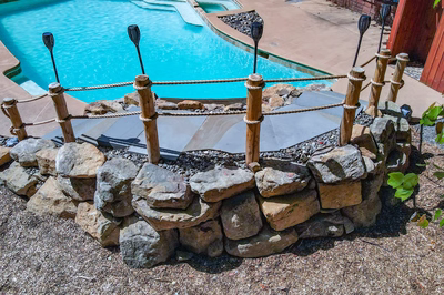 Vernal N - Media, PA - A wooden fence around a swimming pool with rocks and pebbles around it