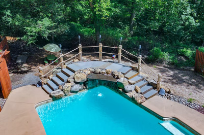 Vernal P - Media, PA - A backyard with a swimming pool surrounded by trees and a wooden fence