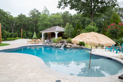Victoria C - Stafford, NJ - A large rectangular swimming pool surrounded by lush greenery and a gazebo