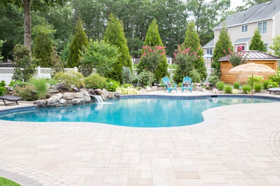 Victoria D - Stafford, NJ - A backyard with a swimming pool surrounded by lush greenery and flowers