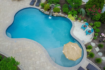 Victoria E - Stafford, NJ - A beautiful backyard with a swimming pool surrounded by lush greenery and flowers