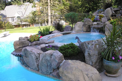 Wagner C - Media, PA - A swimming pool surrounded by rocks and plants with a waterfall.