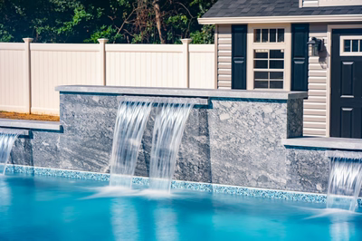 Waireinga C - Bel Air, MD - A swimming pool with a waterfall feature in front of a house