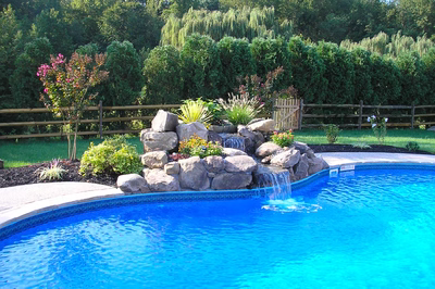 Wallaman A - Mt. Laurel, NJ - A swimming pool with a waterfall and landscaping around it