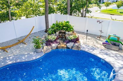 Willamette I - Barnegat, NJ - A backyard with a swimming pool surrounded by a white fence and lush greenery
