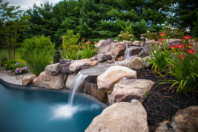 Willey D - Moorestown, NJ - A beautiful garden with a waterfall and colorful flowers around a swimming pool