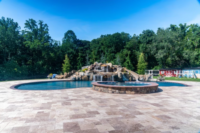 Yakso M - Mullica Hill, NJ - A large rectangular pool with a waterfall in the middle surrounded by lush green trees