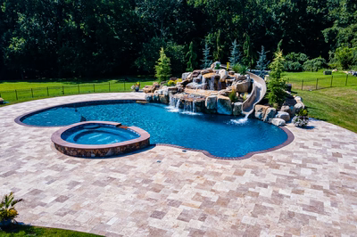 Yakso P - Mullica Hill, NJ - A swimming pool with a waterfall and a waterfall feature surrounded by lush green grass