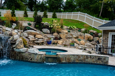 Yosemite M - Newtown Square, PA - A swimming pool with a waterfall in the middle surrounded by rocks and plants