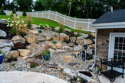 Yosemite N - Newtown Square, PA - A rock garden with potted plants and a white fence.