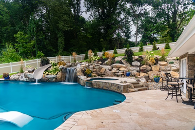 Yosemite O - Newtown Square, PA - A backyard with a swimming pool and a waterfall feature