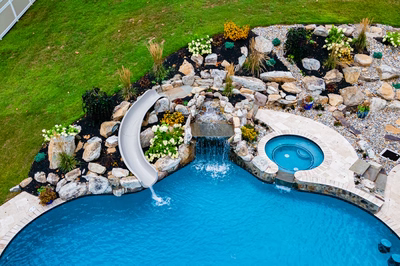 Yosemite P - Newtown Square, PA - A backyard with a swimming pool and a waterfall feature