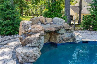 Zealand D - Lutherville, MD - A rock waterfall in the middle of a swimming pool surrounded by lush greenery
