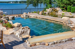 Day U - Manasquan, NJ - A large rectangular swimming pool surrounded by rocks and plants, with a wooden walkway leading to it