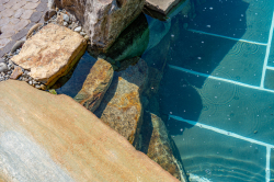 Day Z - Manasquan, NJ - A close-up view of a swimming pool with rocks and pebbles in the water.
