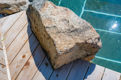Day Z - Manasquan, NJ - A large rock sitting on top of a wooden deck next to a swimming pool