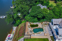 Day Z - Manasquan, NJ - A bird's eye view of a house by a lake surrounded by lush greenery